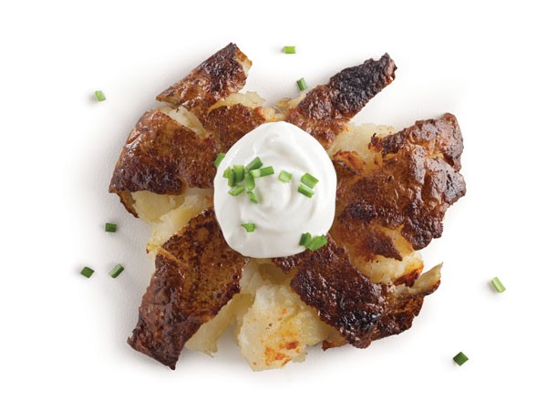 Smashed potato topped with sour cream and chives