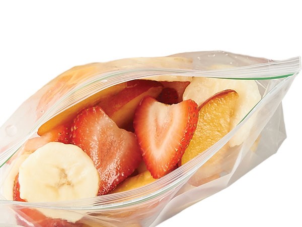 Strawberries, banana, and peaches in resealable plastic bag