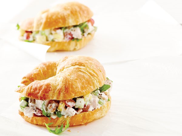 Chicken waldorf salad sandwiched between a sliced croissant 