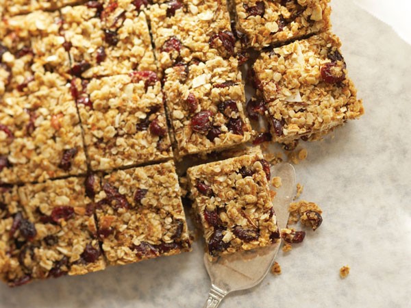 Cut cranberry trail mix bars on parchment paper