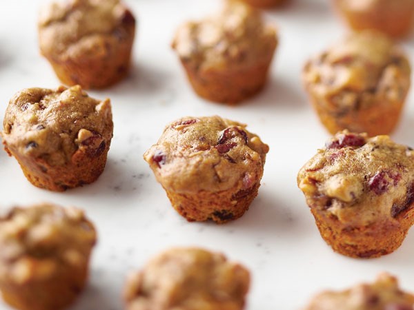 Mini muffins on parchment paper filled with cherries and walnuts