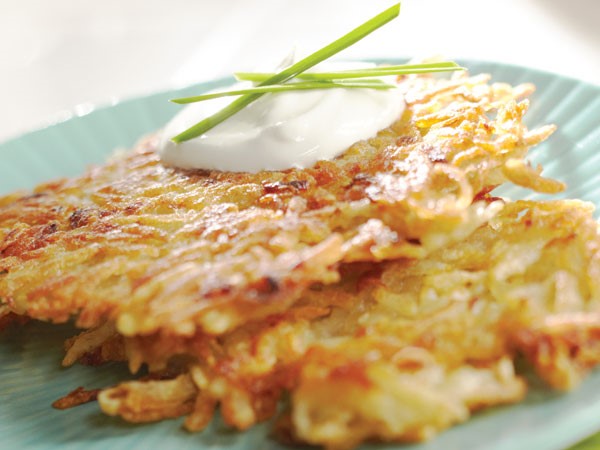 Crunchy potato pancakes garnished with sour cream and fresh chives