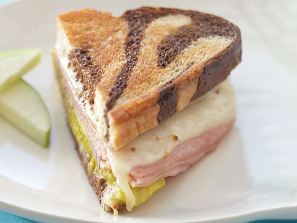 Cuban sandwich filled with garlic-mustard butter served on a white plate