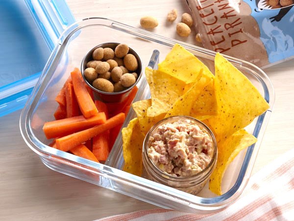 Ham salad in bento box with chips, nuts, and carrot sticks