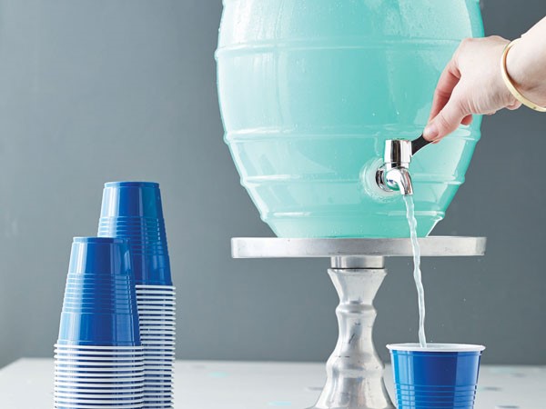 Blue punch poured from a large dispenser 