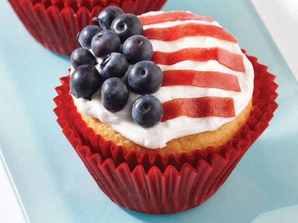 Vanilla cupcakes with frosting and fresh blueberries and sliced fruit strips