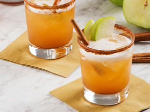 Cocktail made with beer in a cinnamon-rimmed glass and apple garnish