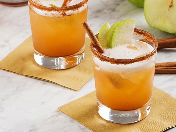 Cocktail made with beer in a cinnamon-rimmed glass and apple garnish