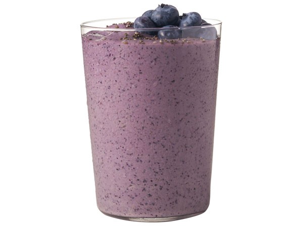 Glass of blueberry madness protein shake topped with fresh blueberries