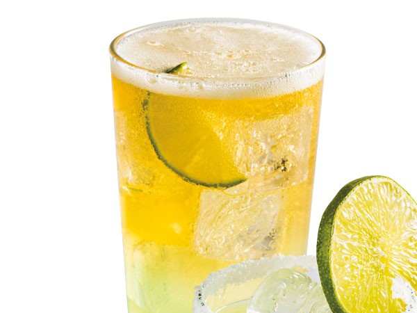 Glass filled with beer-rita, ice and lime slices