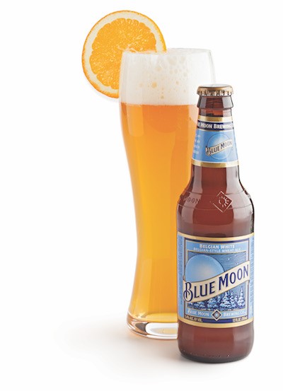 Blue moon beer bottle with beer in hefeweizen glass and orange slice on rim
