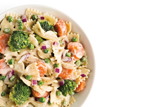 Broccoli pasta salad with fresh veggies in white bowl