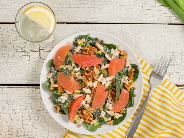 Plate of greens topped with crab, walnuts and slices of grapefruit