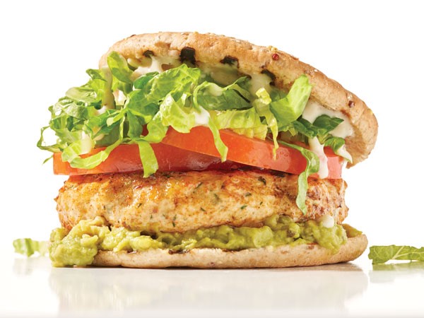 Chicken breast with lettuce, tomato, onion, guacamole and yogurt dressing sandwiched between a split sandwich thin