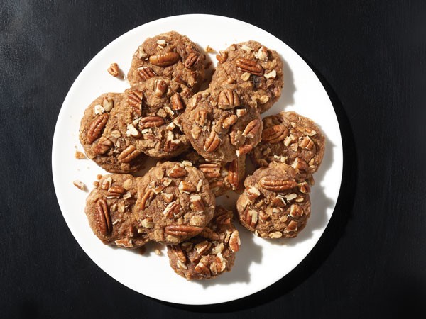 Platter of chocolate banana oatmeal cookies topped with pecans