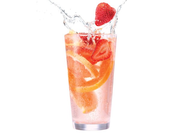 Glass of citrus berry sangria with ice, strawberries and orange slices