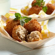 Paper basket filled with baked mushroom arancini balls