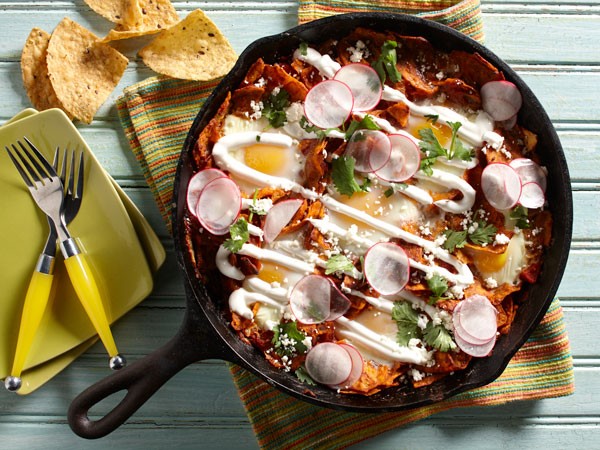 Harissa chilaquiles skillet topped with sour cream, cotija cheese and thinly sliced radishes