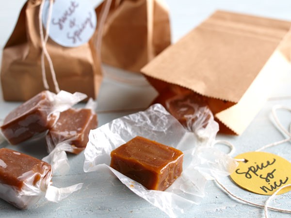 Wax-paper wrapped caramel squares and decorated brown paper bags