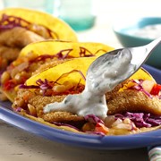 Platter of breaded fish tacos topped with hatch pepper cream