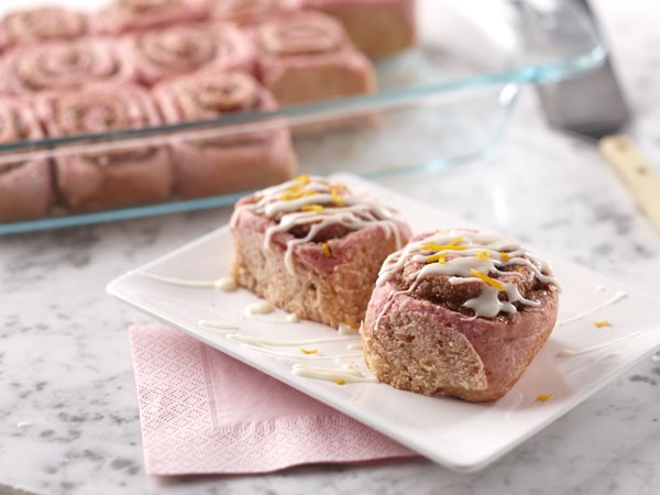 White Platter of Pink Cinnamon Rolls drizzled in Icing