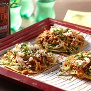 Red tray of beer-marinated chicken toastadas