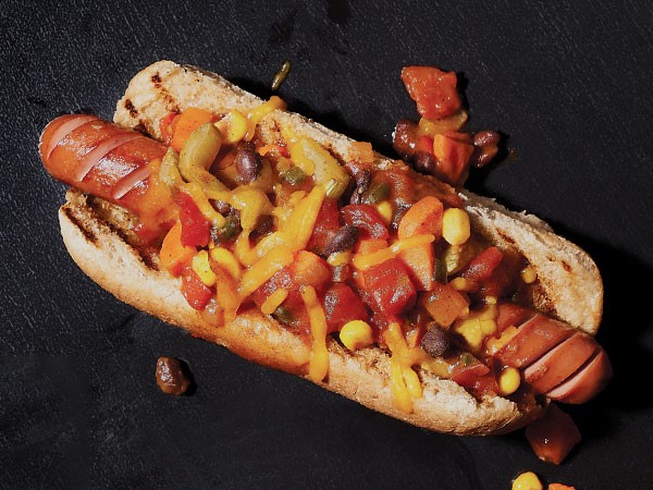 Chili dog topped with mustard, tomatoes, onion and cheese