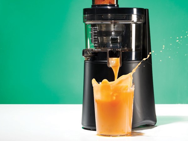 sweet potato pineapple juice coming out of a juicer