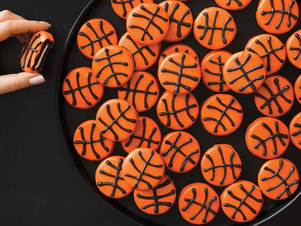 Small basketball cookies made for slam dunking on a black background