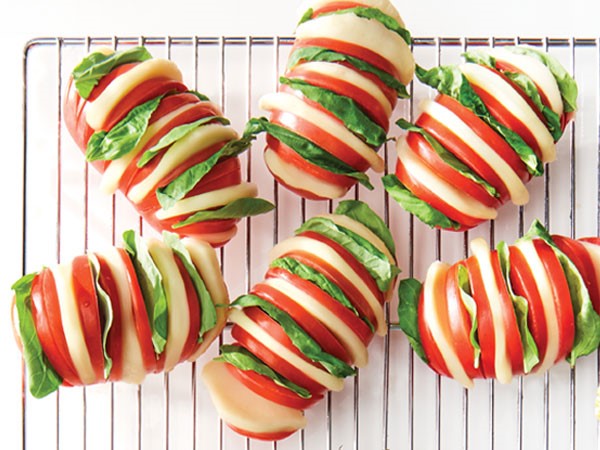 Hasselback tomatoes stuffed with fresh basil and fresh slices of mozzarella