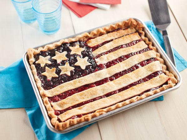 A sheet pan pie with a flag design made out of star-shaped pie crust and strips of pie dough.