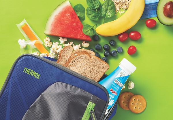 Lunchbox with whole grain bread, milk, cheese, fruit, avocado, and crackers