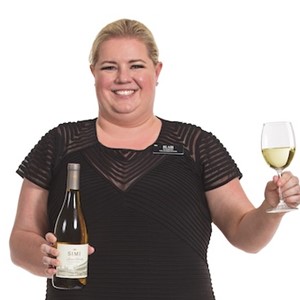 Hy-Vee Sommelier Blair Zachariasen holding a glass of white wine