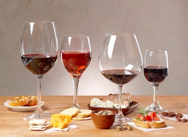 Four glasses of red wine with appetizers and finger foods