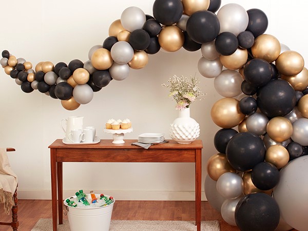 black and gold balloon garland over table