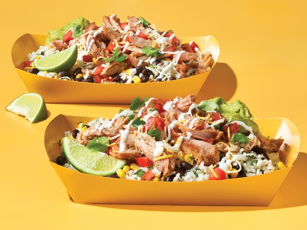 Pulled pork burrito bowls in rectangle yellow takeout boats on a yellow background.