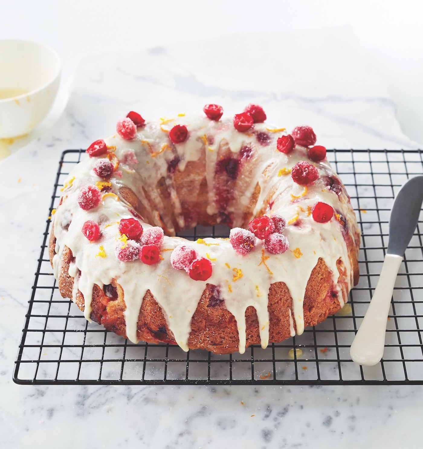 Bunt Fruit Cake Topped with Icing, Sugared Cranberries and Orange Zest