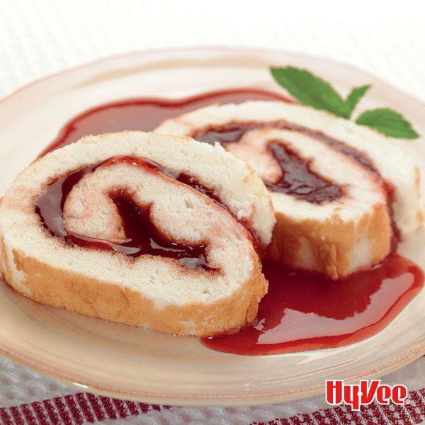 Slices of angel food cake roll with raspberry jam on a plate