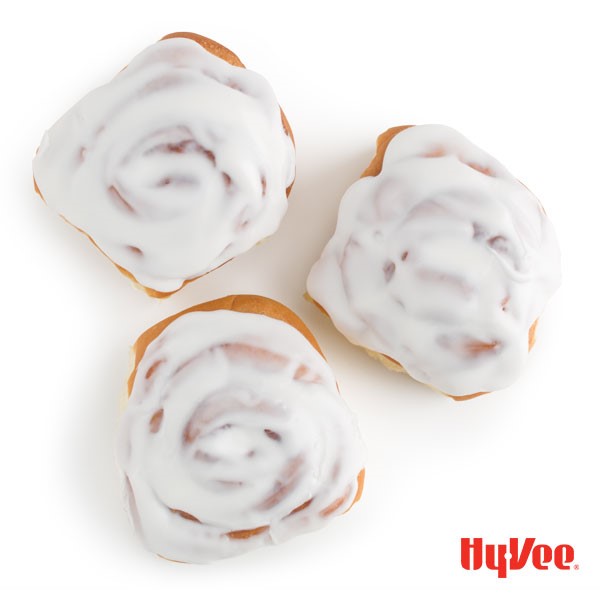 Three cinnamon rolls topped with white icing