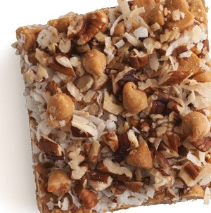 Seven layer bars topped with chopped nuts, shredded coconut, and butterscotch chips