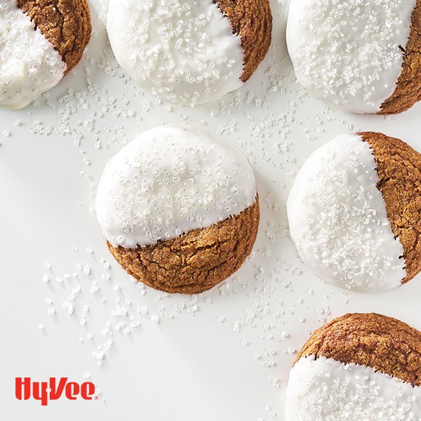 Molasses cookies half dipped in white chocolate and topped with white coarse sugar