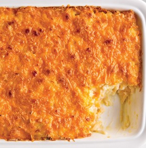 Casserole dish of Cheesy Potatoes with a slice taken out of the pan