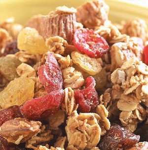 Granola with nuts and dried fruit in yellow bowl