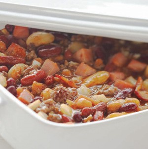 White casserole dish filled with baked calico beans