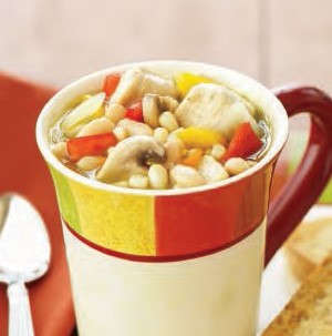 Mug filled with chicken chili with diced mixed vegetables