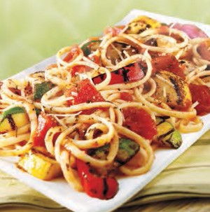 White platter with linguini, grilled squash, grilled red onion, and grilled red bell pepper strips