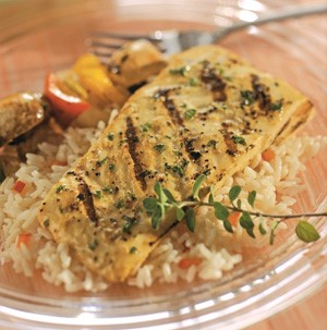 Grilled halibut on top of rice with thyme sprig