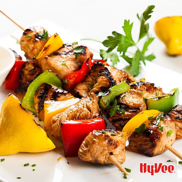 Dijon chicken and red, green and yellow bell peppers on wooden skewers