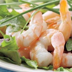 Grilled tail-on shrimp on a bed of mixed greens and garnished with fresh chives