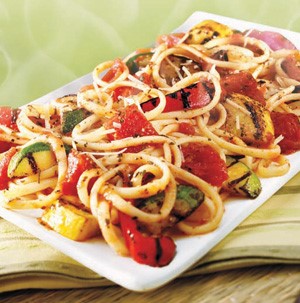 White platter with linguini, grilled squash, grilled red onion, and grilled red bell pepper strips